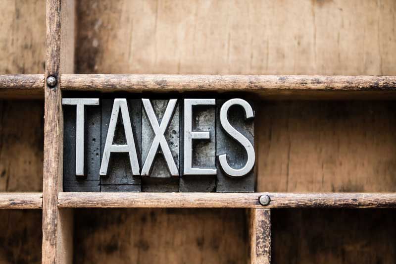metal stamp that says "taxes," IRS guidelines on excess executive pay at tax-exempt organizations
