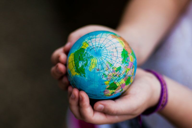 child holding a globe, THE World University Rankings for 2020.